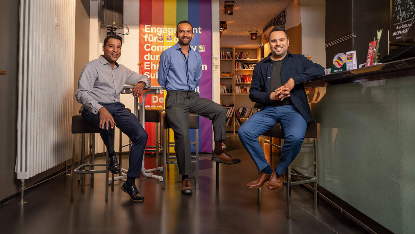 Menschen in einem bar-ähnlichen Umfeld, die Offenheit und Diversity in München darstellen.