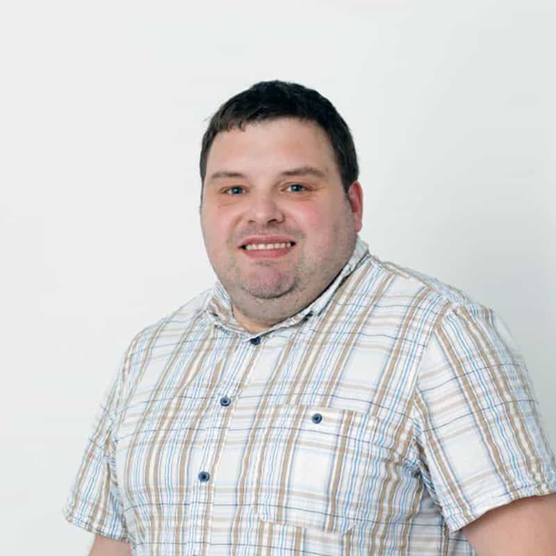 Freundlicher schwuler Mann in München, lächelnd, casual Kleidung.